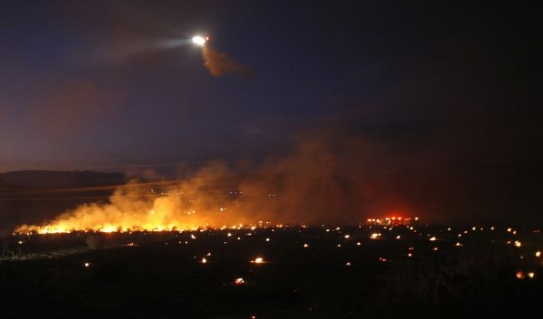 Helikoptéra shazuje svůj náklad na požár nedaleko Los Angeles.