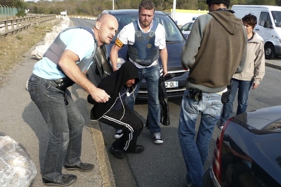 Pohraniční policie zatýká v Calais nelegálního imigranta. 