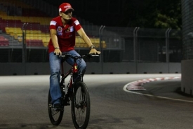 Pilot Ferrari Giancarlo Fisichella si na kole proj&iacute;žd&iacute; z&aacute;vodn&iacute; trať.