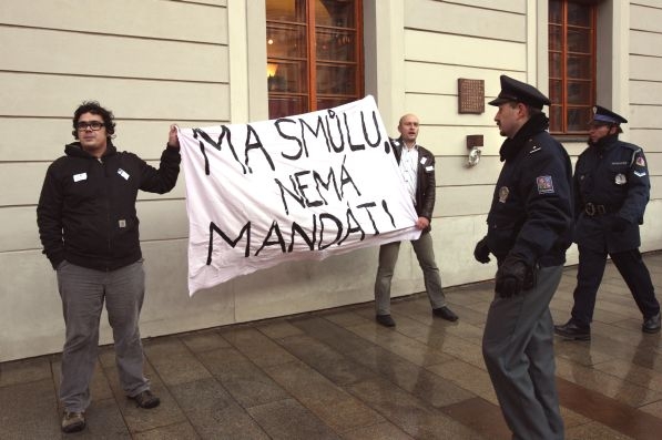 Muži rozvinuli před Klausovou kanceláří transparent.