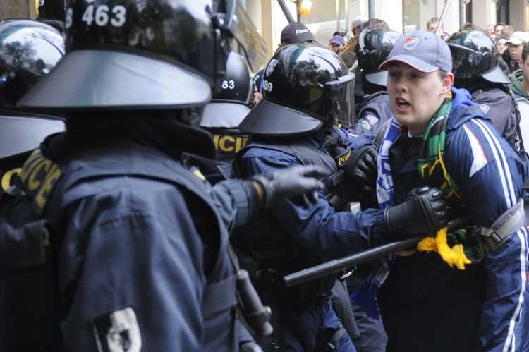 Fanoušek fotbalistů Baníku Ostrava a zasahující policisté.
