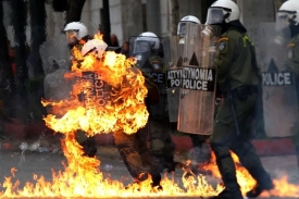 Po policistech házejí demonstranti benzínové bomby.