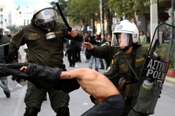 Řečtí policisté zatýkají jednoho z demonstrantů.