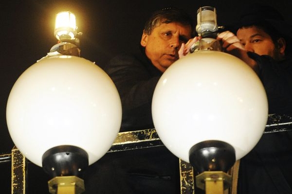 Premiér Fischer zapaluje obří svícen na pražském Palachově náměstí.
