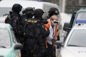 Lupič, kterého policisté odvádějí v poutech, mohl mít komplice.
