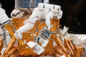 Mike Massimino při v&yacute;měně gyroskopů a bateri&iacute; Hubblova teleskopu.