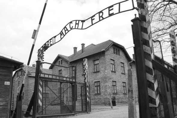 Arbeit macht frei, viselo vězňům nad hlavou.