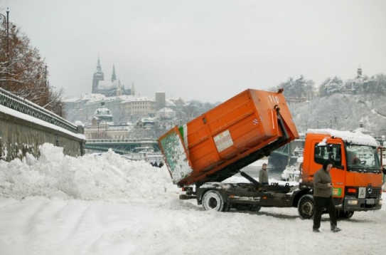 Silničáři sníh navážejí k náplavce u nemocnice Na Františku.