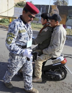 Irácký policista se skenerem kontroloje motocykl.