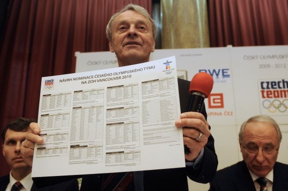 Šéf české mise Dvořák ukazuje seznam sportovců. 