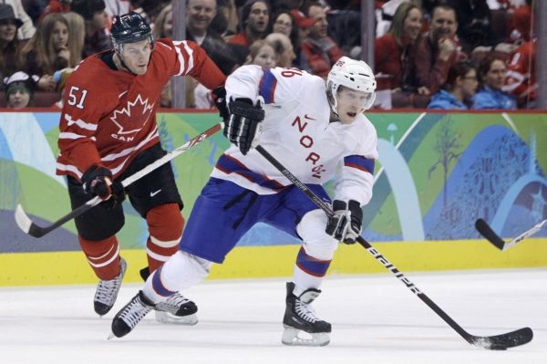Ryan Getzlaf z týmu Kanady stíhá Nora Mathise Olimba.