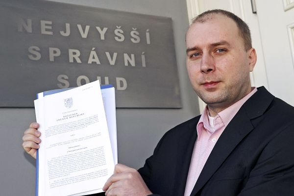 Tiskový mluvčí NSS Emmert předvádí rozsudek o sociálním pojištění.