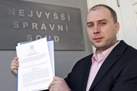 Tiskový mluvčí NSS Emmert předvádí rozsudek o sociálním pojištění.
