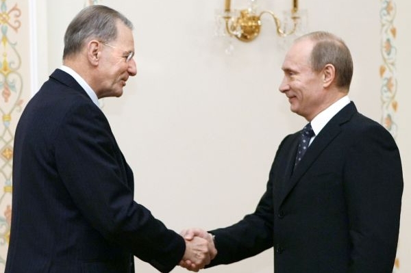 Putin se zdraví s představitelem Mezinárodního olympijského výboru.