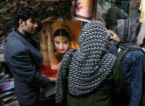 Bohaté mladé Afghánky si prohlížejí plakát z bollywoodského filmu.