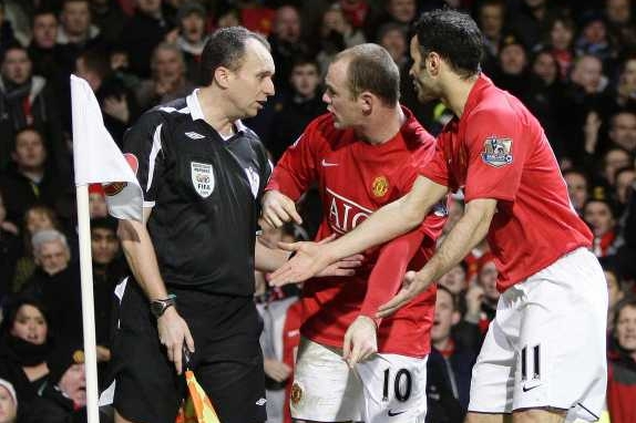 Hráči Manchesteru Rooney a Gigs předvědčují sudího, že gól má platit. Hráči Manchesteru Rooney a Gigs předvědčují sudího, že gól má platit.