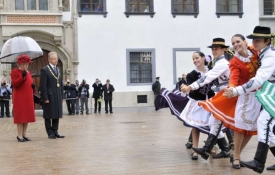 Alžběta II. a primátor Ďurkovský sledují show folklorního souboru.