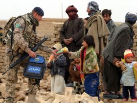 Německý voják rozdává hračky afghánským dětem.