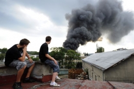 Na pomoc přijeli i pražští hasiči, nad továrnou létají vrtulníky.