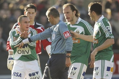 Rozhodčí Bernhard Brugger v obklíčení hráčů Austrie. Rozhodčí Bernhard Brugger v obklíčení hráčů Austrie.