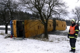 Autobus dostal smyk a převrátil se kolmo na vozovku.