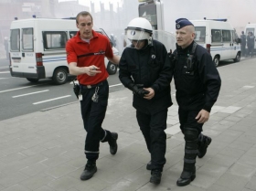 Kolegové odvádějí policistu zraněného při střetu s rybáři.