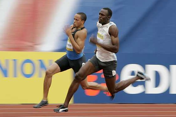 Jamajčan Usain Bolt (v bílém), světový rekordman v běhu na 100 metrů.