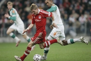 Fotbalista Bayernu Mnichov Bastian Schweinsteiger bojuje o míč s brazilským hráčem Werneru Brémy Naldem během nedělního utkání v mnichovské Allianz aréně.