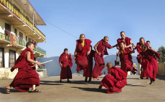 Mladí buddhističtí mniši si hrají před klášterem. Všední život Tibetu.