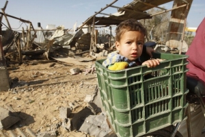 D&iacute;tě v ko&scaron;&iacute;ku na kole Palestince v uprchlick&eacute;m t&aacute;boře.