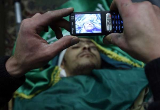 Poslední podobenka. Palestinci fotí mladíka zabitého při bombardování. Poslední podobenka. Palestinci fotí mladíka zabitého při bombardování.