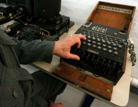 Muzeum v Bletchley Park v Británii. Herec předvádí práci s Enigmou.