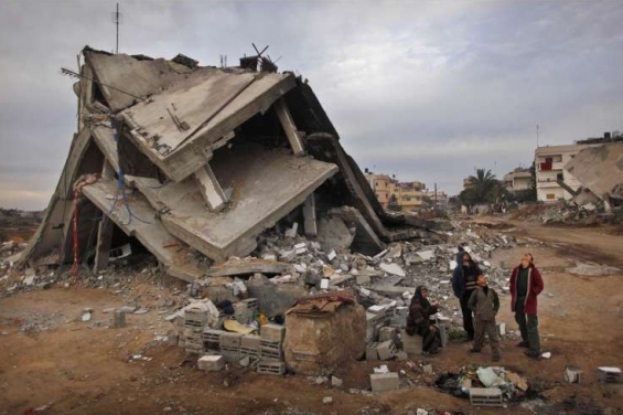 Palestinci u svého zničeného domu sledují izraelský letoun. Palestinci u svého zničeného domu sledují izraelský letoun.