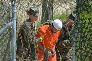 Američtí vojáci vedou vězně z věznice Guantánamo