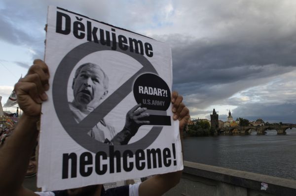 Účastník demonstrace vyjadřuje pomocí transparentu svůj názor.
