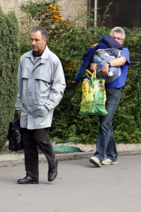 Zklamaní zaměstnanci odcházejí se svými věcmi ze sklárny.