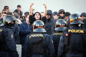 Fanoušek Dinama ukazuje zdvižené prostředníky na pražské policisty.