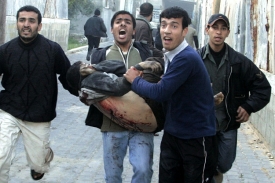 Palestinci nesou dal&scaron;&iacute;ho zraněn&eacute;ho při izraelsk&eacute;m bombardov&aacute;n&iacute;.