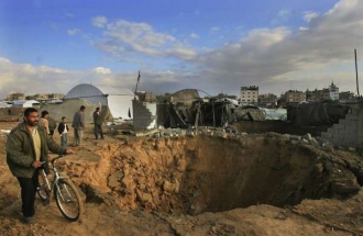 Palestinci si prohl&iacute;žej&iacute; zničen&yacute; pa&scaron;er&aacute;ck&yacute; tunel po dopadu bomby.