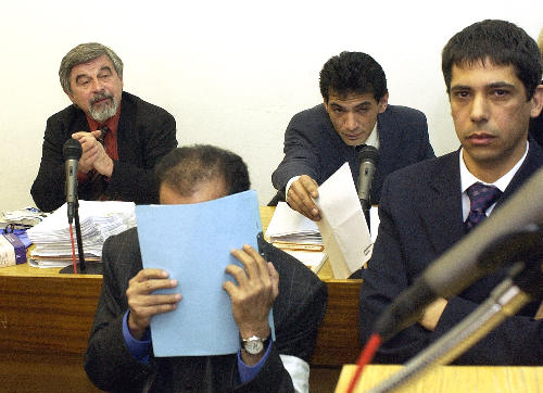 Listem papíru si kryje tvář člen katarské královské rodiny Abdal Sání.