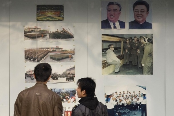 Kim Čong-il (vpravo) a Kim Il-sung na výstavce. Oba hlídali Francouzi.