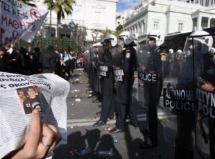 Demonstranti ukazuj&iacute; policistům sn&iacute;mek zřejmě zavražděn&eacute;ho hocha.