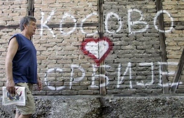 Obyvatel Bělehradu kráčí kolem nápisu: Kosovo je srdce Srbska.