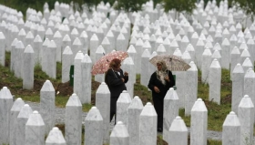 Bosensk&eacute; pozůstal&eacute; obět&iacute; masakru v Srebrenici proch&aacute;zej&iacute; u pam&aacute;tn&iacute;ku.