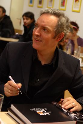 Neil McCormick podepisuje knihu U2 o U2 na pražsk&eacute;m křtu.
