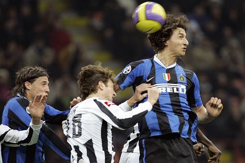 Za Inter Milan Zlatan Ibrahimovic (vpravo) a obránce Marco Motta z Undine skáče pro míč s Hernanem Crespem (vlevo).