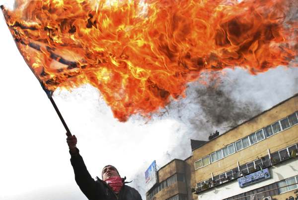 Palestinec pálí izraelskou vlajku na protest proti izraelské ofenzivě. Palestinec pálí izraelskou vlajku na protest proti izraelské ofenzivě.