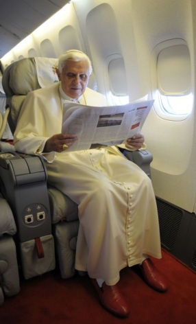 Papež čte v letadle noviny. Přirozeně vatik&aacute;nsk&eacute; L'Osservatore Romano.
