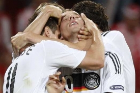 Lukas Podolski přijímá gratulace od spoluhráčů.