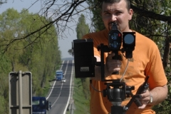 Policista v civilu měří rychlost radarem.